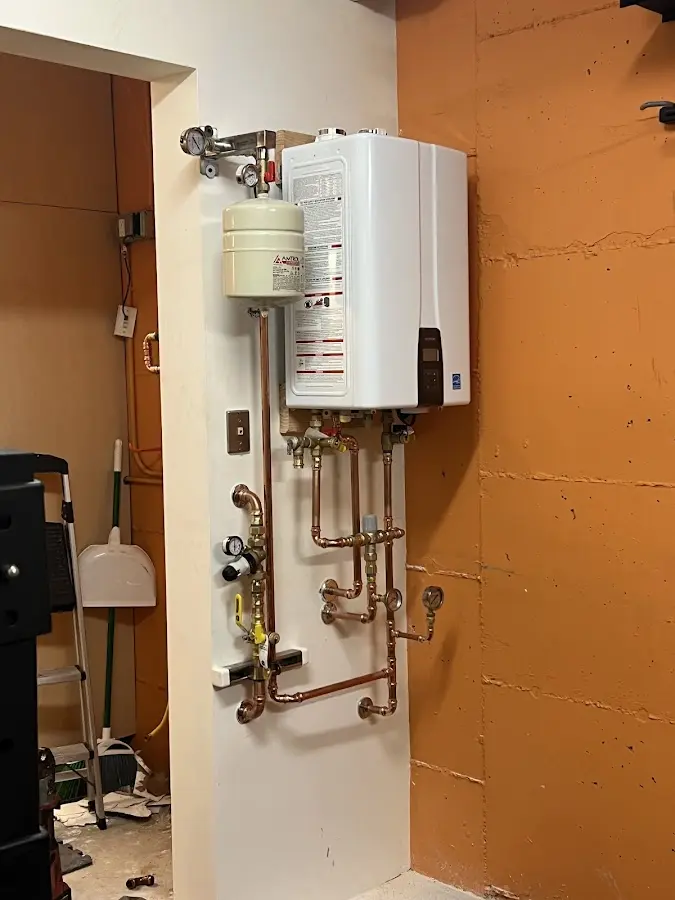 Plumbing technician inspecting water heater connections in Taylorville
